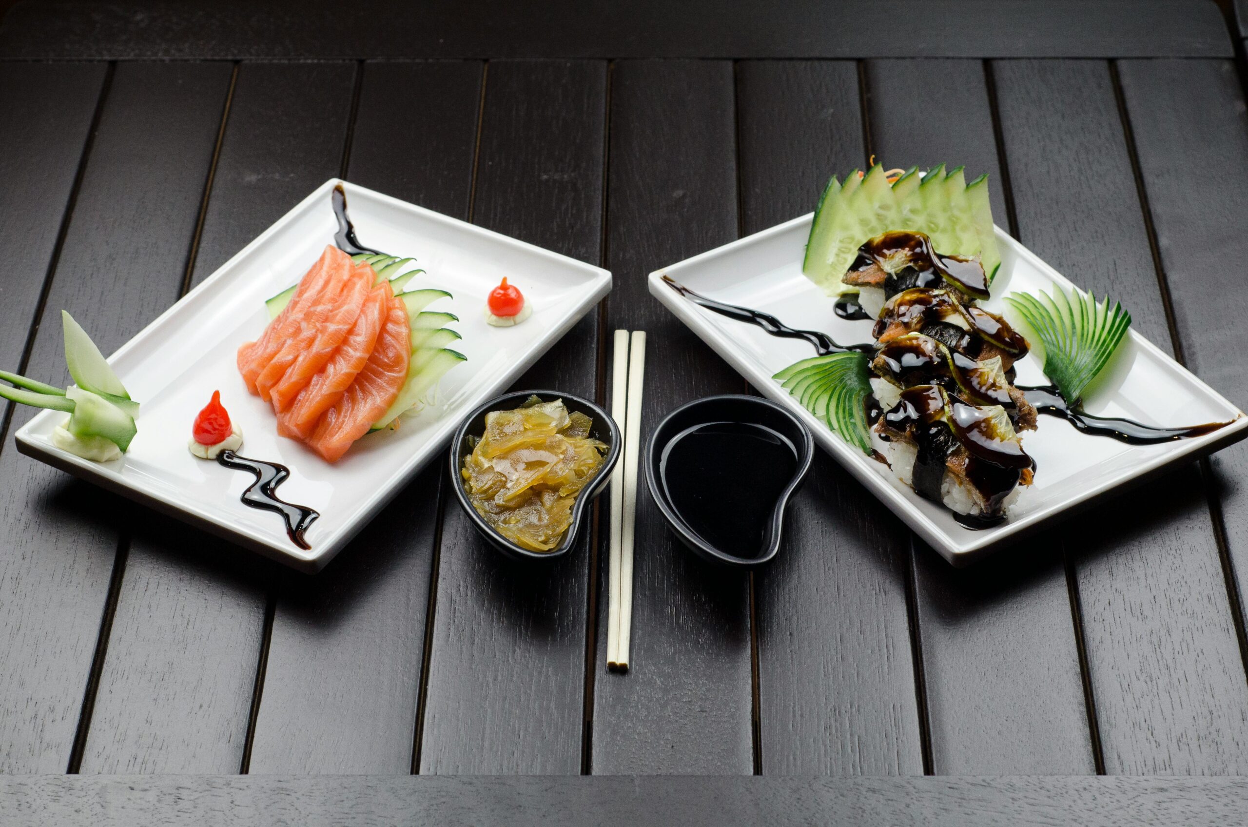 Elegant display of Japanese sushi and sashimi on a dark wood table.